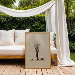 Puede incluir: Una impresi&oacute;n art&iacute;stica enmarcada representa a una persona con una pila de libros en la cabeza, caminando con un malet&iacute;n. La obra de arte est&aacute; en una paleta de colores neutros. La impresi&oacute;n se exhibe en una terraza de madera, cerca de un sal&oacute;n exterior blanco.