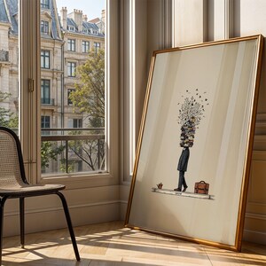 Puede incluir: Una impresi&oacute;n art&iacute;stica enmarcada que presenta una ilustraci&oacute;n surrealista de una persona con una pila de libros en lugar de cabeza, un malet&iacute;n y una peque&ntilde;a planta. La obra de arte tiene un marco dorado y est&aacute; apoyada contra una pared cerca de una ventana.