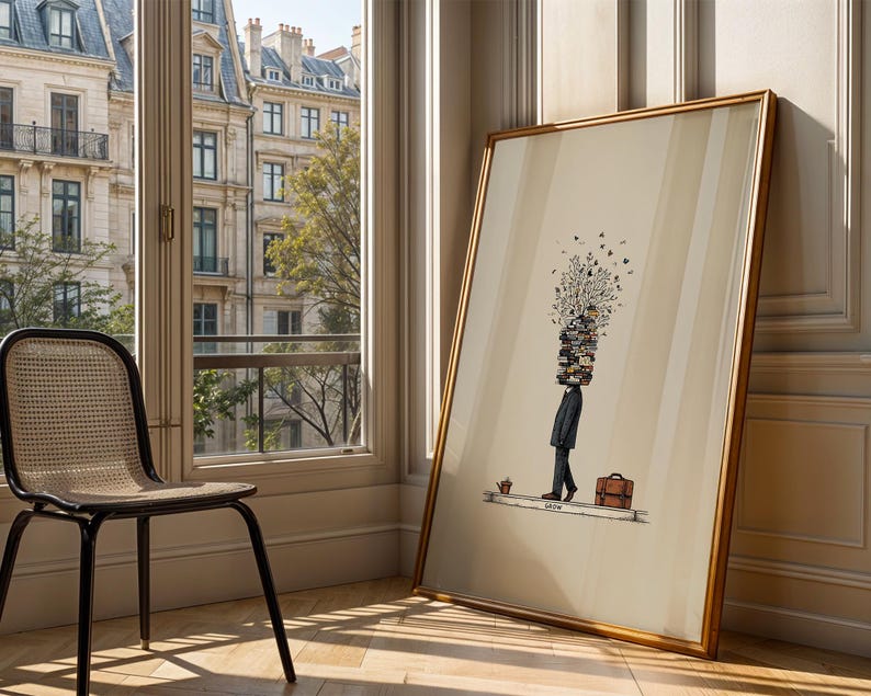 Puede incluir: Una impresi&oacute;n art&iacute;stica enmarcada que presenta una ilustraci&oacute;n surrealista de una persona con una pila de libros en lugar de cabeza, un malet&iacute;n y una peque&ntilde;a planta. La obra de arte tiene un marco dorado y est&aacute; apoyada contra una pared cerca de una ventana.
