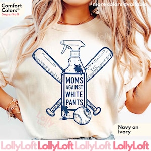 May include: An ivory short-sleeve t-shirt featuring a navy blue graphic of a spray bottle crossed with two baseball bats and a baseball. The text on the bottle reads MOMS AGAINST WHITE PANTS. The shirt has a crew neckline and a relaxed fit.