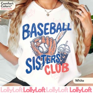May include: White t-shirt with a baseball-themed graphic. The design includes the words "BASEBALL SISTERS CLUB" in blue and red, along with a baseball, glove, bat, and a drink with ice.