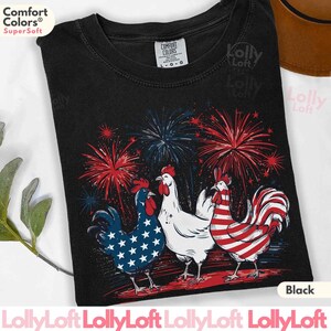 Pode incluir: Camiseta preta com um gr&aacute;fico de tr&ecirc;s galos com designs de bandeira americana. Os galos est&atilde;o cercados por fogos de artif&iacute;cio. O texto "Comfort Colors&reg; Super Soft" est&aacute; no canto superior esquerdo da camiseta. O texto "Black" est&aacute; no canto inferior direito da camiseta.