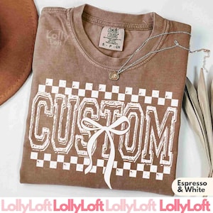 May include: A brown t-shirt with a white checkered pattern and the word "CUSTOM" in white with a white bow in the center. The text "Espresso & White" is visible at the bottom of the image.