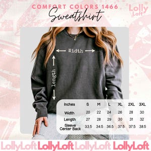 May include: A charcoal grey crewneck sweatshirt with a size chart overlay. The text reads Comfort Colors 1466 Sweatshirt, Lolly Loft, and includes a table with width, length, and sleeve center back measurements in inches for sizes S to 3XL.