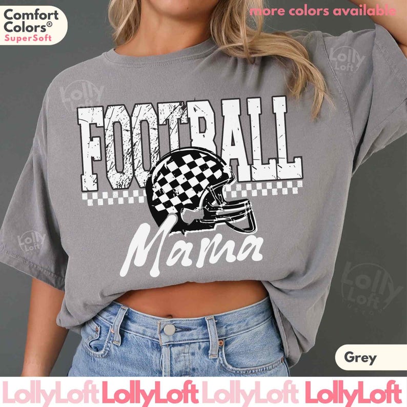 May include: A grey Comfort Colors t-shirt with the words "FOOTBALL Mama" in white. The design includes a football helmet with a black and white checkered pattern. The shirt is a relaxed fit.