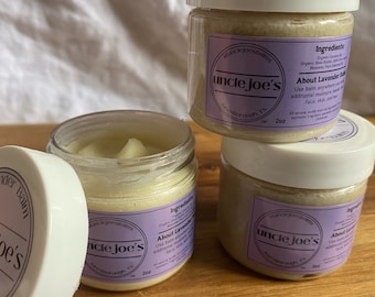 May include: Three glass jars of lavender balm with white lids. The jars are labelled "uncle joe's" and contain a light yellow balm. The labels also list the ingredients, which include organic shea butter, coconut oil, and beeswax. Each jar is 2 oz.