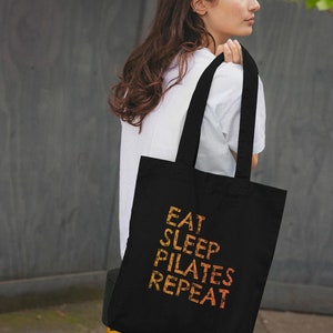 Pilates - themed - Eat Sleep Pilates Repeat - 100% Organic Cotton Tote Bag In Black.