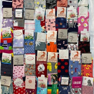May include: A collection of colourful socks with various patterns, including flowers, animals, and geometric designs. The socks are packaged in pairs and labelled with brand names such as "BHR", "Elu", "Ceremony", "Woman Socks", "Dogancan Ladies", "Maksu", "de pier", and "Irge".