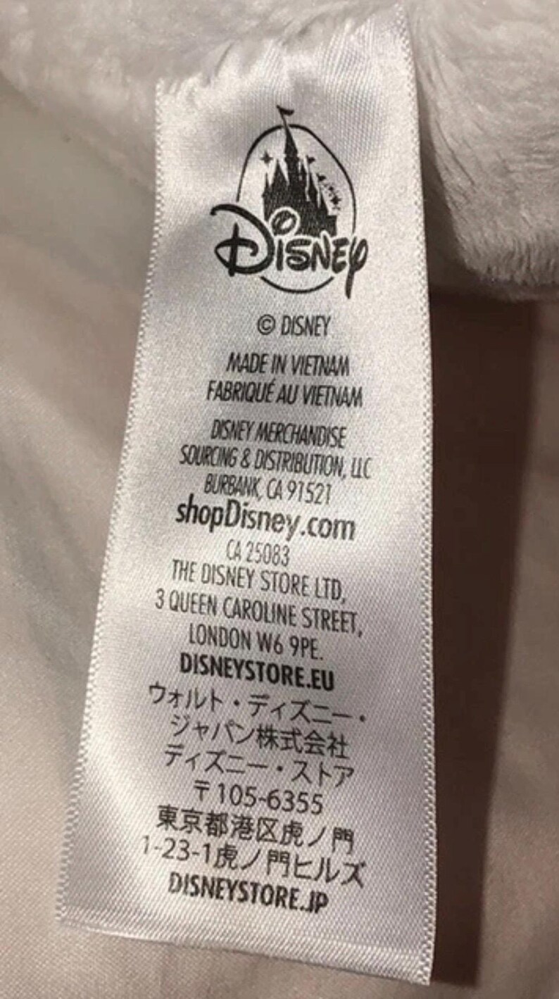 May include: A white tag with the Disney logo and text. The tag includes the text "MADE IN VIETNAM", "shopDisney.com", and addresses for Disney merchandise and The Disney Store Ltd.