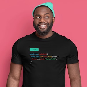May include: A black t-shirt with a code snippet printed on it. The code is written in Java and displays the classic "Hello, World!" program. The code is highlighted in different colors, including blue, red, and green.