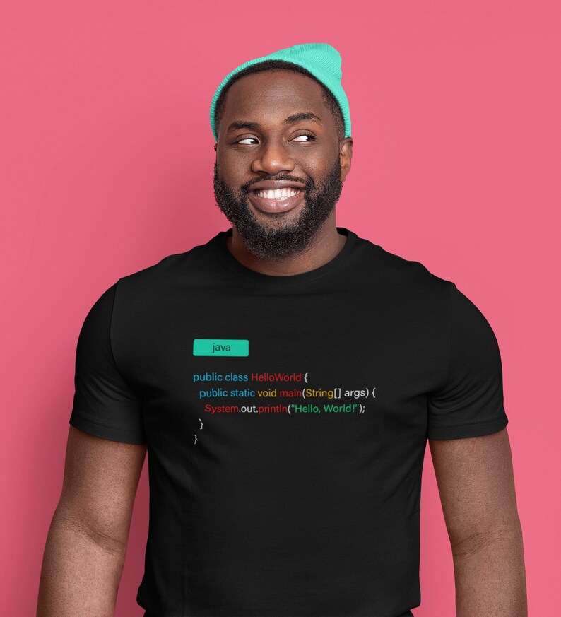 May include: A black t-shirt with a code snippet printed on it. The code is written in Java and displays the classic "Hello, World!" program. The code is highlighted in different colors, including blue, red, and green.
