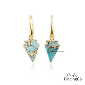 May include: A pair of gold earrings with turquoise arrowhead-shaped stones. The stones are a mix of blue and gold.