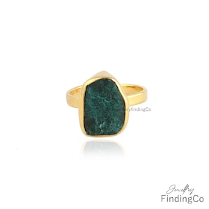 Peut inclure: Une bague en or avec une grande pierre précieuse verte de forme irrégulière. La bague est sertie sur une bande simple.