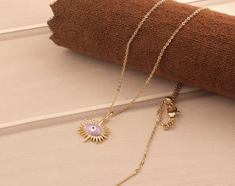 Puede incluir: Un collar de cadena dorada con un colgante de ojo turco morado. El colgante tiene un diseño de rayos de sol alrededor del ojo.