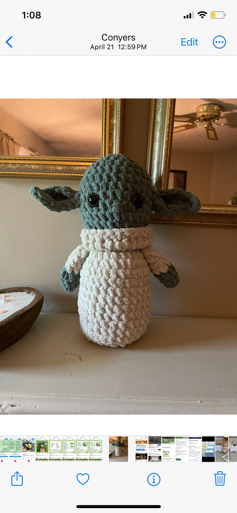 Op de afbeelding: Een gehaakt pluche speelgoed dat lijkt op een personage uit de Star Wars-franchise. Het speelgoed is groen en wit en heeft grote oren. Het speelgoed staat op een plank.