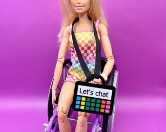 Doll sized acrylic AAC device with elastic carry strap for display, decoration and to represent diverse communication and support inclusion