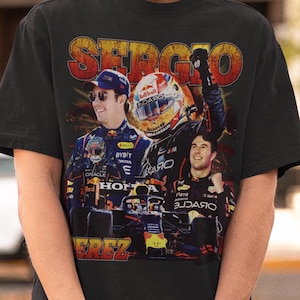 May include: A black t-shirt with a vintage-style graphic of a Formula One race car driver. The graphic features the text "Sergio Perez" and the driver's name in a bold, yellow font.