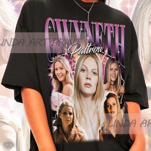 May include: Black t-shirt with a graphic print of Gwyneth Paltrow's face in a collage of different images. The text "Gwyneth Paltrow" is printed in purple on the shirt.