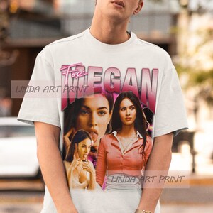 Peut inclure: T-shirt blanc avec un imprim&eacute; graphique rose et blanc de Megan Fox. Le graphique comprend trois images de Megan Fox et le texte "Fox Megan".