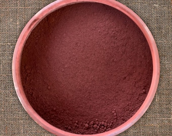 May include: A round, terracotta-colored bowl filled with a fine, deep red powder.