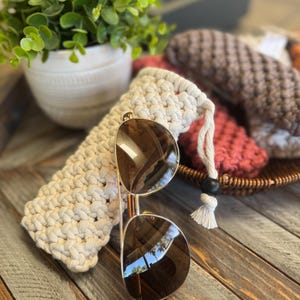 May include: A white ceramic mug with a black handle and the text "But First, Coffee" in a black, bold font. The mug is sitting on a wooden surface. The mug is 4 inches tall.