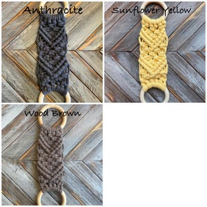 Pu&ograve; includere: Tre arazzi in macram&egrave; con corda annodata in antracite, giallo girasole e marrone legno. Ogni pezzo presenta un motivo a chevron ed &egrave; fissato a due anelli di legno liscio di colore chiaro alle estremit&agrave; superiore e inferiore.