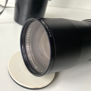 Puede incluir: Un objetivo Vivitar 135mm f/2.8 teleobjetivo negro para una c&aacute;mara de 35mm. El objetivo est&aacute; fabricado por la empresa 'Maroxat'.