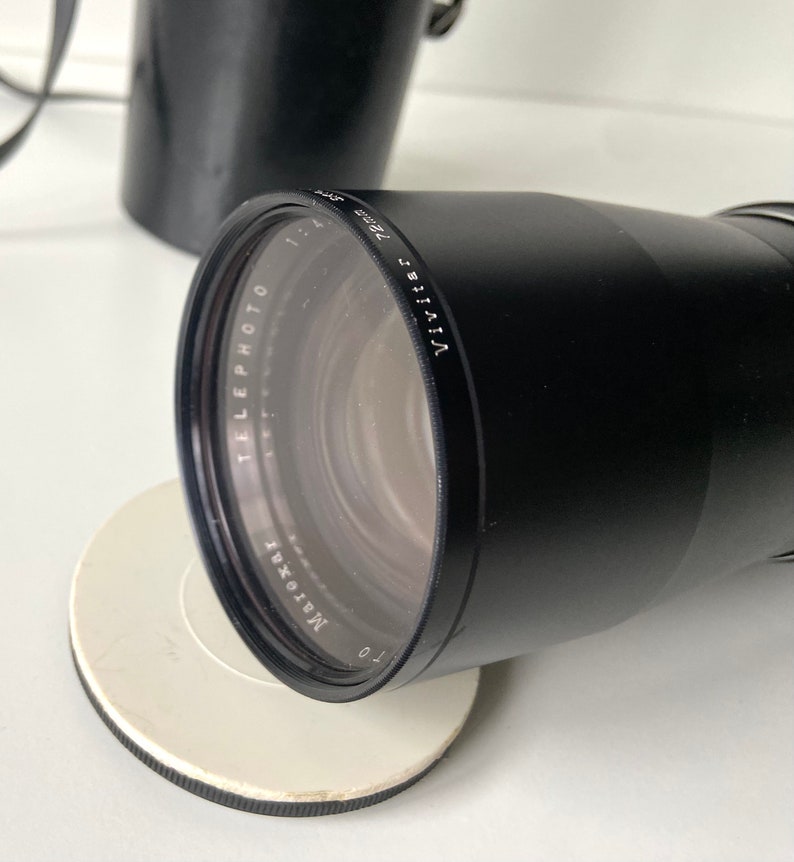 Puede incluir: Un objetivo Vivitar 135mm f/2.8 teleobjetivo negro para una c&aacute;mara de 35mm. El objetivo est&aacute; fabricado por la empresa 'Maroxat'.