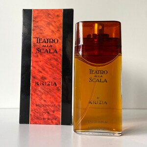 Pu&ograve; includere: Un flacone di profumo Teatro Alla Scala di Krizia in vetro marrone. Il flacone &egrave; da 100 ml e ha un'etichetta dorata con il nome del marchio e il nome del prodotto.
