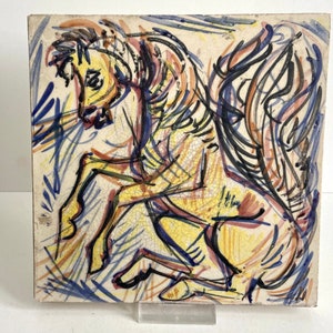 May include: A yellow, blue, and black abstract painting of a horse on a white tile. The horse is depicted in a dynamic pose with its legs outstretched and its head turned to the side. The painting is done in a loose, expressive style with bold strokes of color.