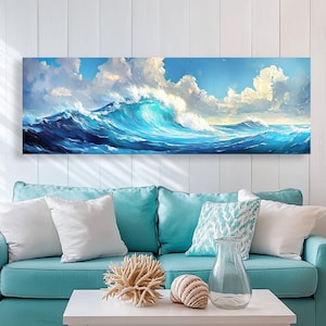 Pode incluir: Um sofá azul turquesa com almofadas brancas e estampadas fica em frente a uma grande impressão em tela de uma onda azul do oceano quebrando contra um céu nublado.