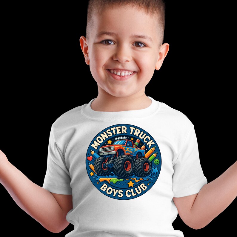 Puede incluir: Camiseta blanca con un dise&ntilde;o de cami&oacute;n monstruo colorido. El dise&ntilde;o circular incluye el texto "MONSTER TRUCK BOYS CLUB", un cami&oacute;n monstruo azul, naranja y rojo, l&aacute;pices y estrellas.