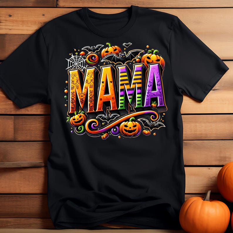 May include: Black t-shirt with a Halloween-themed design featuring the word "MAMA" in colorful, stylized letters surrounded by bats, pumpkins, and spiderwebs.