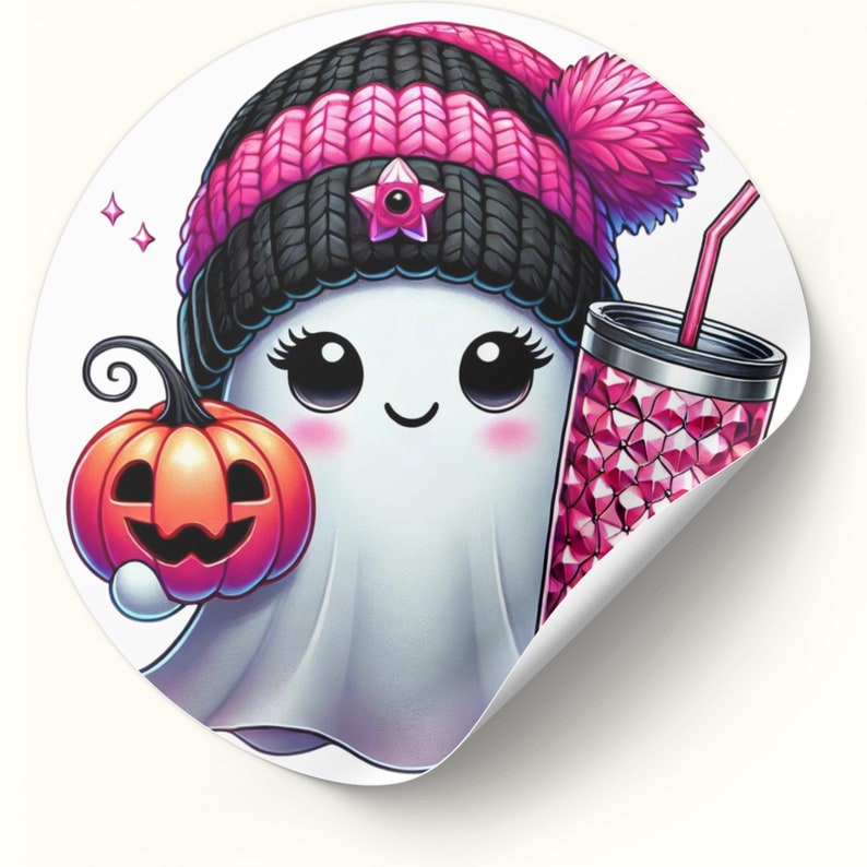 May include: A white ghost wearing a pink and black knit hat with a pom-pom, holding a small orange pumpkin and a pink glittery cup with a straw.