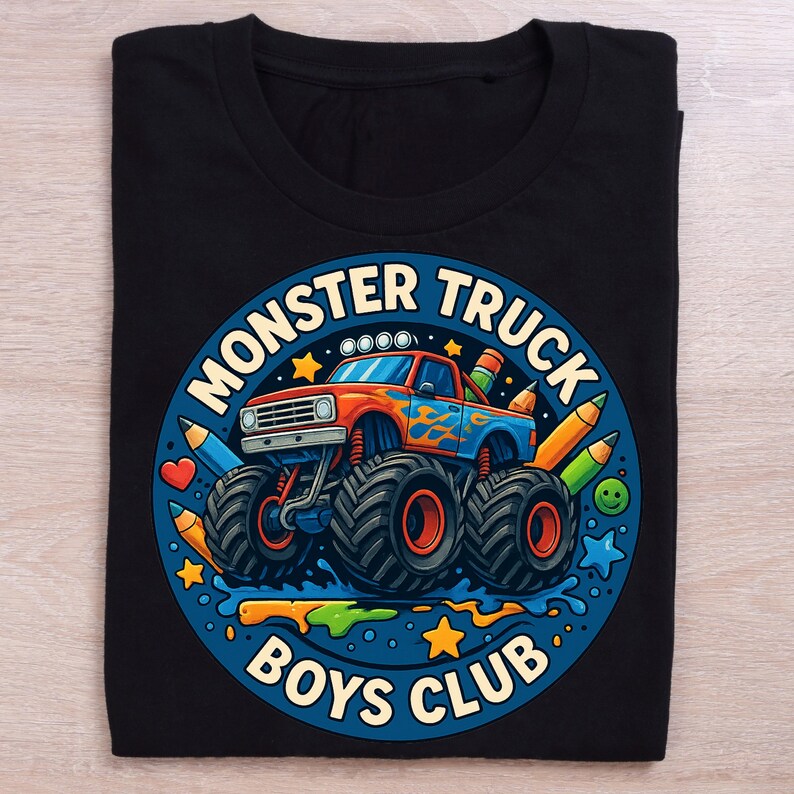 Puede incluir: Camiseta negra con un dise&ntilde;o de cami&oacute;n monstruo colorido. El dise&ntilde;o circular incluye las palabras "Monster Truck Boys Club", l&aacute;pices, estrellas y un coraz&oacute;n. El cami&oacute;n es rojo y azul con llamas.
