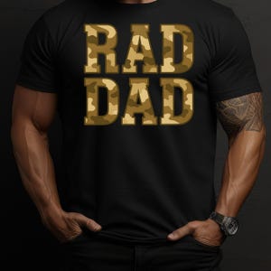 May include: Black t-shirt with the words "RAD DAD" in camouflage print. The text is in a bold, blocky font, and the camouflage pattern features shades of brown and green. The shirt is a classic crew neck style.