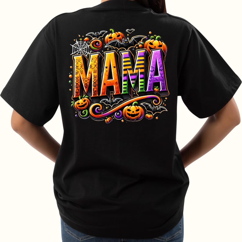 May include: Black t-shirt with a Halloween-themed design featuring the word "MAMA" in colorful, stylized letters surrounded by pumpkins, bats, and a spider web.