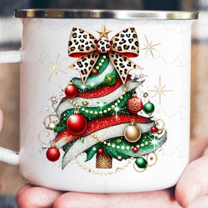 May include: White ceramic mug with a Christmas tree design. The tree is decorated with red and green ornaments, a leopard print bow, and gold glitter.