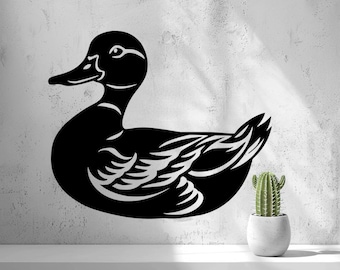May include: A black wall decal featuring a stylized silhouette of a duck with white negative space detailing on the wings and head, positioned on a textured wall surface next to a small green cactus in a white pot.