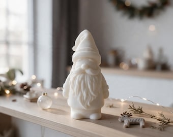 May include: A white, matte-finish figurine of a gnome with a long, flowing beard and a pointed hat. The gnome stands upright with a rounded body, detailed facial features, and a smooth texture, presented as a singular decorative object.