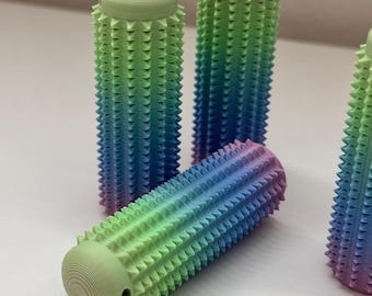 May include: Four colorful, textured, cylindrical grips with a gradient of green, blue, and purple. The grips have a spiky texture.