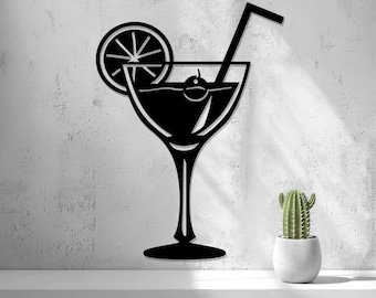 May include: A black metal wall art piece shaped like a cocktail glass with a straw, a citrus slice garnish, and a cherry inside. The silhouette features a long stem and a wide base, presented as a flat, solid graphic design element.