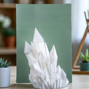 May include: A white, crystalline sculpture resembling a cluster of quartz crystals. The sculpture is set against a green background with a geometric pattern. The piece is displayed on a wooden surface, suggesting a decorative item.