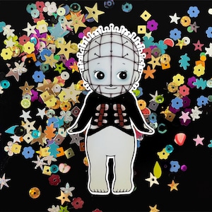 May include: A white and black character with a grid-like head and a black and white striped shirt. The character is standing on a black background with colorful confetti.