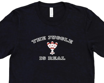 May include: A black t-shirt with white text that reads "The Juggle is Real" and a graphic of three red and white juggling pins.