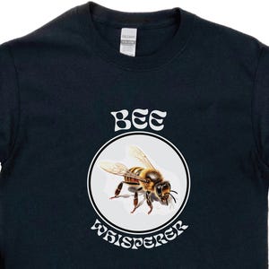 May include: Black long-sleeve sweatshirt with a white graphic of a bee and the text "Bee Whisperer".