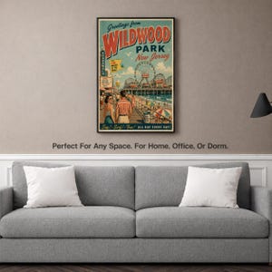 May include: A framed vintage-style poster with the text "Greetings from WILDWOOD PARK New Jersey." The poster features a boardwalk scene with a Ferris wheel, people, and the words "Sun! Surf! Fun! ALL DAY EVERY DAY!"