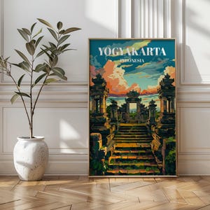 May include: A framed art print showing a colourful illustration of Yogyakarta, Indonesia. The artwork depicts a stone temple complex with a staircase leading to a central gate, set against a vibrant sky. The text "YOGYAKARTA INDONESIA" is displayed at the top.