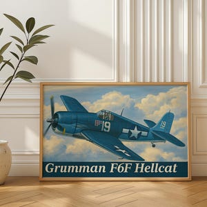 May include: A framed print of a Grumman F6F Hellcat aircraft in flight, painted in shades of blue with white accents. The plane features a white star and the number 19. The background shows a cloudy sky. The text "Grumman F6F Hellcat" is at the bottom.
