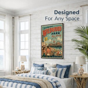 May include: A framed vintage-style poster with the text "Greetings from Wildwood Park New Jersey" hangs above a bed with blue and white striped bedding. The poster features a boardwalk scene with a Ferris wheel. The room has white walls and a coastal theme.